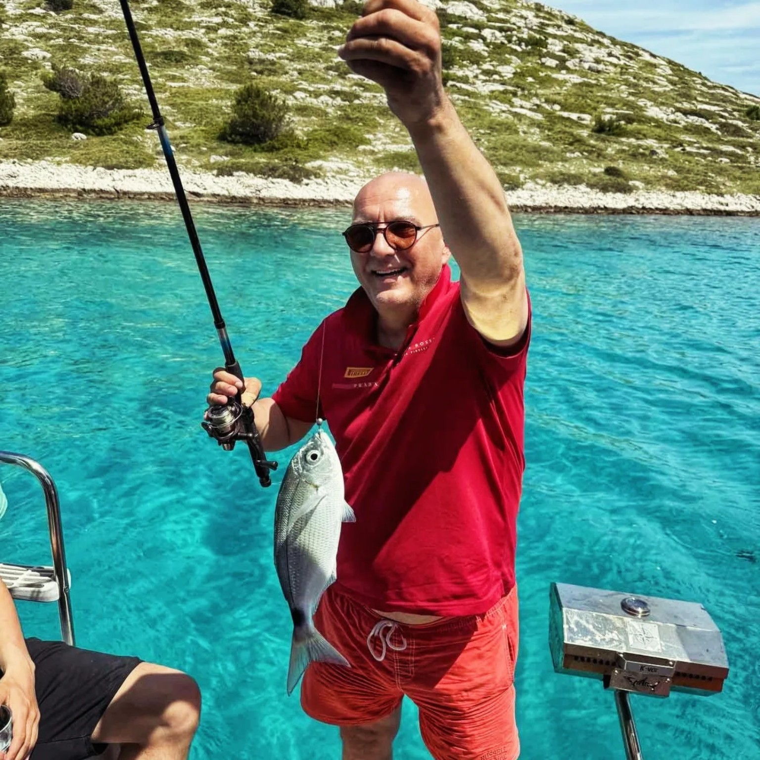 Guest holding a fresh fish caught during a sailing trip